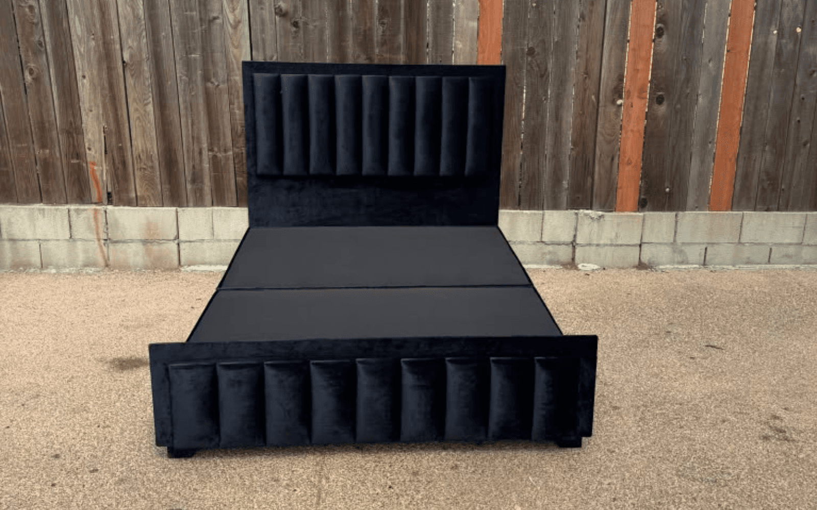 Bespoke black velvet bed with a vertical channel-tufted headboard and matching panelled footboard