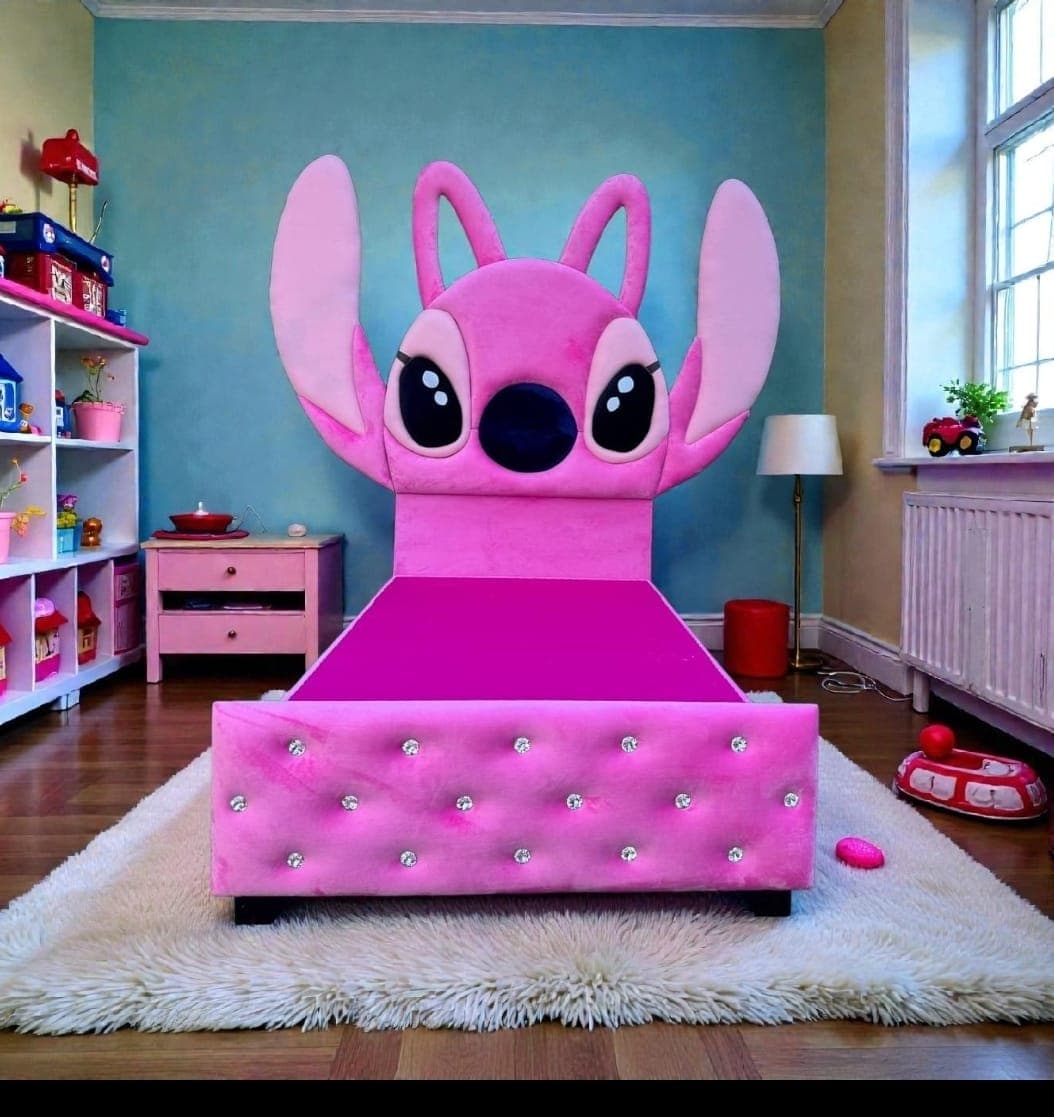 Angel Bed in a child's room, a tall pink plush headboard sculpted as a character's face with long ears above a footboard set with crystal-style buttons